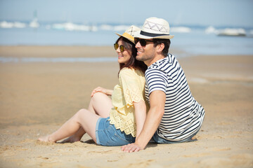 happy couple hugging and laughing together at the beach