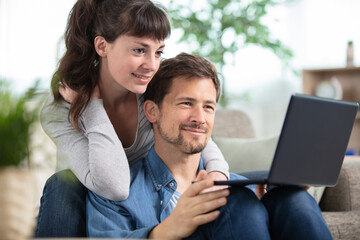 Fototapeta premium happy millennial couple sit relax on couch in living room