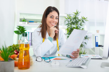 portrait of young smiling female nutritionist in the consultation room