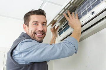 air conditioning technician preparing to install new air conditioner