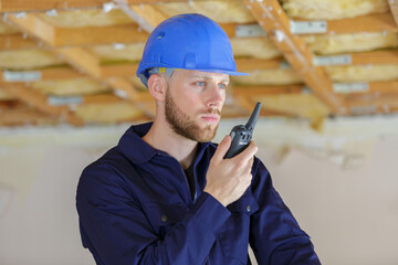 young male builder using a walkie talkie