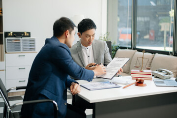 Asian business team and lawyers discussing contract papers sitting at the table. Concepts of law, advice, legal services.