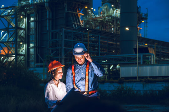 Petroleum refinery industry engineer night time working team. Power plant engineering workers teamwork plant evening survey support.