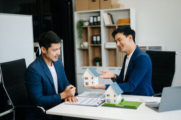 balancing the property sector The real estate agent is explaining the house style to see the house design and the purchase agreement.