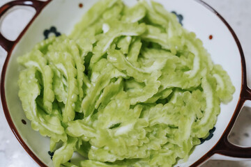 Sliced bitter melon or bitter gourd in plate for cooking