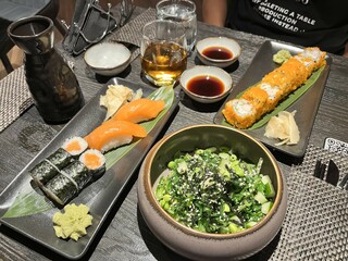 Japanese food. A delicious fresh seaweed salad, salmon sushi nigiri, sushi roll on a black plate. Japanese cuisine. 