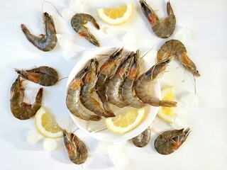Healthy food. Fresh shrimps with ice and lemon on bowl on white background top view