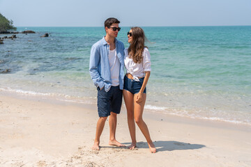 Happy romantic moment couple enjoying sunny day at the beach, man and woman smile and look relaxed, romance, vacation, beach life, summer holiday relaxation and summer fun, love by the sea concept