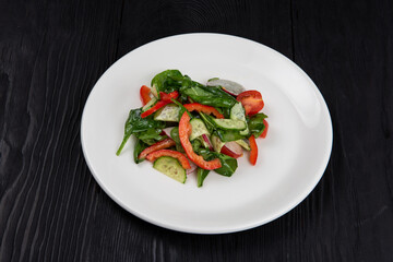 Fresh vegetable salad of cucumbers, tomatoes, raddish, bell pepper, basil and olive oil.