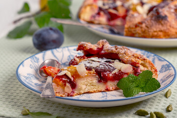 Piece of open pie (galette) with plums.