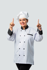 Happy Indian Female Chef or professional cook Pointing at blank - Isolated on White