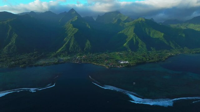 Golden hour sunset towering mountain peaks surf reef break channel Teahupoo Wave Tahiti French Polynesia aerial drone view incredible island landscape Olympics Moorea Bora Bora Papeete backwards