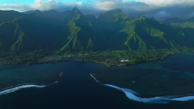 Golden hour sunset towering mountain peaks surf reef break channel Teahupoo Wave Tahiti French Polynesia aerial drone view incredible island landscape clouds Olympics Moorea Bora Bora Papeete forward