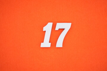 The numbers are made of white painted wood. Placed on the floor was orange paper.