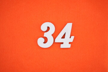 The numbers are made of white painted wood. Placed on the floor was orange paper.