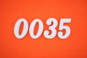 The numbers are made of white painted wood. Placed on the floor was orange paper.