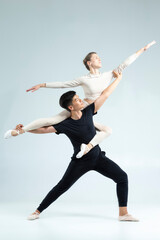 Dance Ideas. Flexible Passionate International Sportive Couple of Asian Man and Caucasian Woman Performing As Ballet Dancers On Grey in Studio During Suppots © danmorgan12