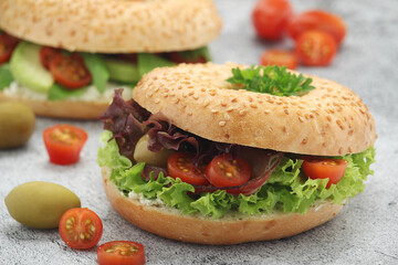 Sesame bagels with tomatoes, ham and olives	