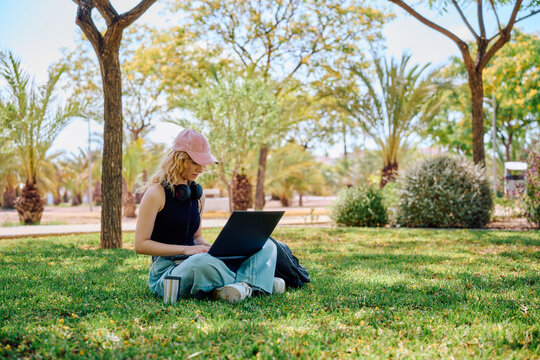 Student working on laptop in a campus park