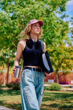 Student walking on campus with coffee