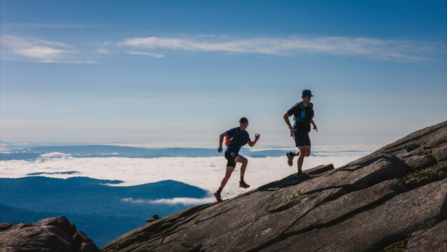 Two young men trail run above the clouds up Baldface Mountain, NH