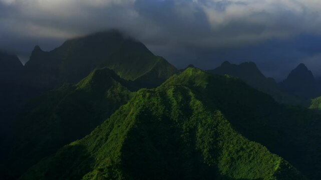 Sunset light towering mountain peaks valley town village Teahupoo Tahiti French Polynesia aerial drone view incredible dark clouds island landscape Moorea Bora Bora Papeete circle right