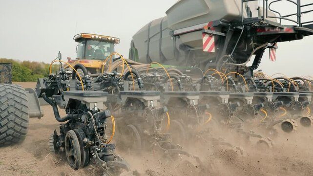 Modern Seeder in Action on Farmland, A close-up view of a modern seeder at work, planting seeds in a tilled field. The machinery is detailed with complex components,