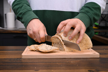 Kroić chleb orkiszowy na zakwasie żytnim na desce do krojenia z bliska