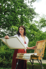 Female artis paints a picture in the park. Mindfulness, art therapy, creativity concept. Process of plein air painting in nature. A series of photos showing the step-by-step creation of a painting