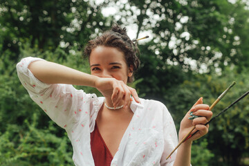 Female artis paints a picture in the park. Mindfulness, art therapy, creativity concept. Process of plein air painting in nature. A series of photos showing the step-by-step creation of a painting