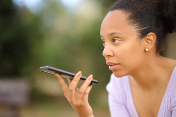 Serious black woman dictating message on phone