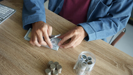 Man planning finances Count banknotes and coinsใ