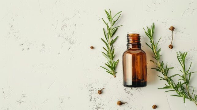 Essential oil bottle and rosemary on a bright backdrop