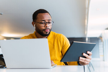 business, people and technology concept - african american businessman with laptop and tablet pc...