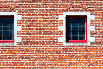 Windows of traditional medieval house exterior on red brick wall, Belgium