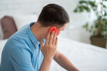Man with earache at home, ear pain and otitis