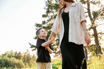 Obraz premium Having a walk. Mother and son are in the forest together