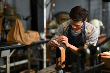 Skilled leatherworker meticulously stitching leather for leather products in the local workshop