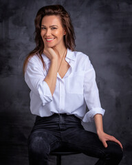 Studio portrait of a brunette haired woman cheerful smiling against isolated background