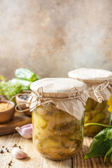 Healthy homemade fermented food. Salted pickled cucumbers salad preserved canned in glass jar. Home economics, autumn harvest preservation. Copy space.