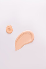 A sample, a stroke and drop of foundation powder in a natural tone. cosmetic swatch. Mockup for the design of the cosmetic texture of the product.