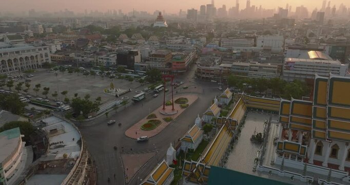 An aerial view of Red Giant Swing and Suthat Thepwararam Temple at sunset scene, The most famous tourist attraction in Bangkok, Thailand.