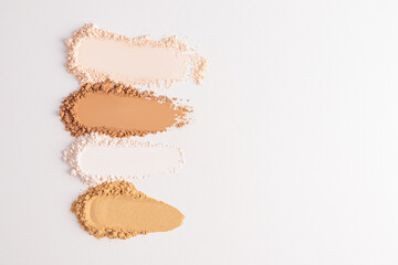 Several samples of loose powder in different tones on a white background with a copy space. . Layout, a sample for texture design and advertising.