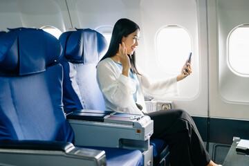 Asian Woman Working on Tablet During  in first class, multitasking with Flight Travel in style, work