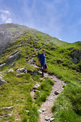 Fototapeta premium Exhausted hiker with backpack on a trail in the mountains