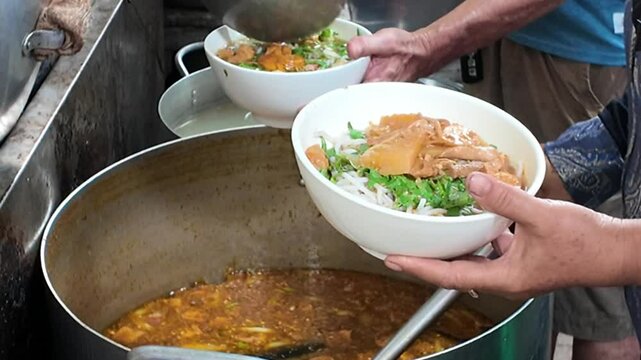 Chef scoop broth to vegan beef rice noodles or bun bo to serve diners in kitchen of restaurant, this famous Vietnamese street food, vegetarian meal good for health