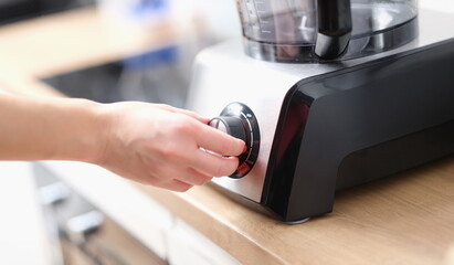 Close-up woman using blender to make tasty dish. Female hand touching speed controller. Cooking...