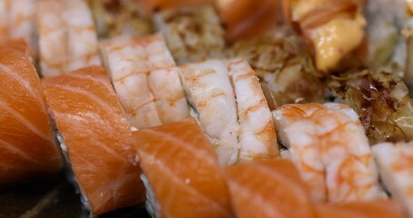 Top view of set of sushi rolls with salmon and shrimps, japanese traditional food. Sushi restaurant or cafe menu concept