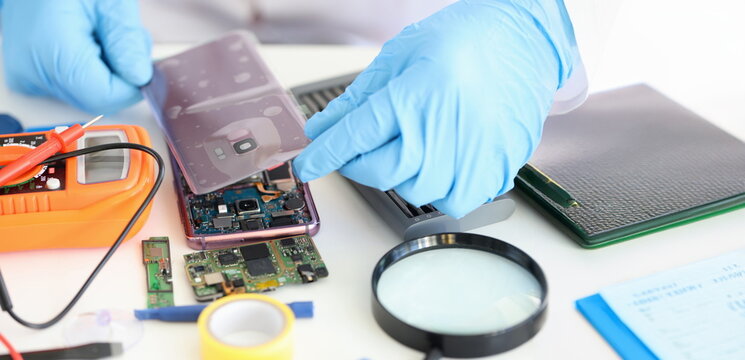 Close-up of technician repairing mobile phone, electronic smartphone technology. Cellphone assembly and disassembly concept