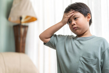 Portrait of sick depressed unhappy child boy touching on head feel suffering head ache pain flu high fever, alzheimer, cancer, stroke, parkinson, disease, cerebral haemorrage, encephalitis, dementia